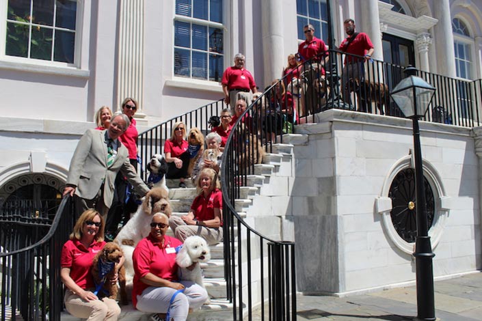 April 30, 2018: a few MUSC Therapy Dog teams took a group photo with the Honorable Mayor John Tecklenburg on the steps of City Hall after he honored our four legged therapists.