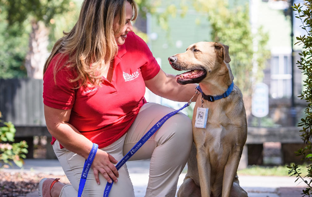 An MUSC volunteer with a therapy dog. Photo provided by Jeanne Taylor Photography.